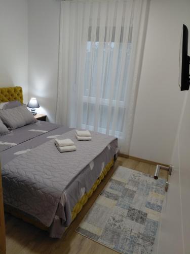 a bedroom with a bed with two towels on it at Rajsko sunce in Vrnjačka Banja