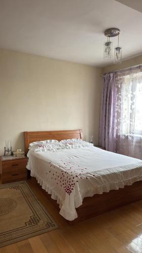 a bedroom with a large bed with white sheets and a window at Near ASA Arena Circus in Ulaanbaatar