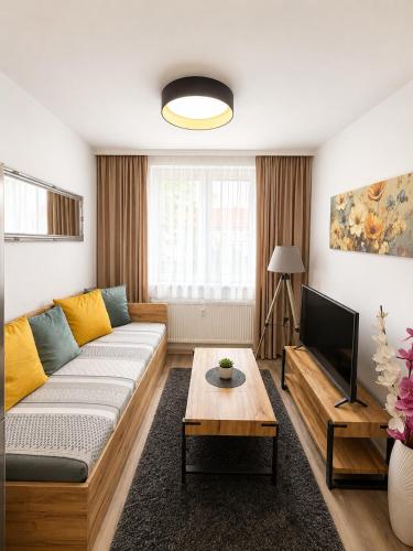 a living room with a couch and a tv at Apartmány U Jelena 2 in Český Krumlov