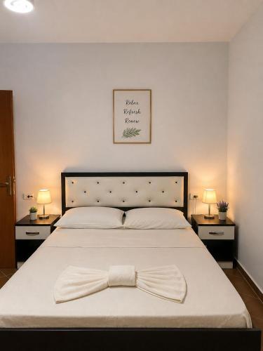 a bedroom with a bed with a bow tie on it at Avela Beach Apartments in Durrës