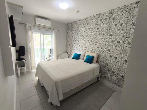 a bedroom with a bed with blue pillows on it at Apartamento Riviera Ilha da Madeira in Riviera de São Lourenço