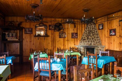 a restaurant with tables and chairs and a fireplace at El Tirol in Cantagallo