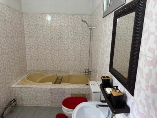a bathroom with a tub and a toilet and a sink at Noble Villa in Abidjan