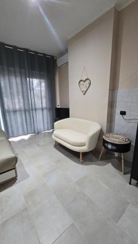 a living room with a white couch and a table at B&B House Novara in Novara