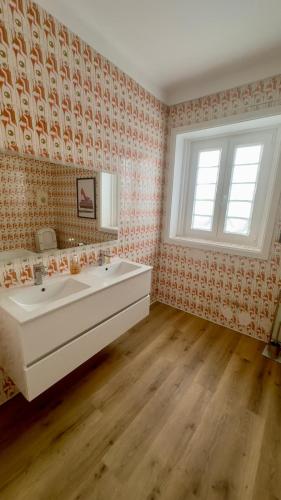 a bathroom with a white sink and a window at Pink-Shell in Santiago de Riba-Ul