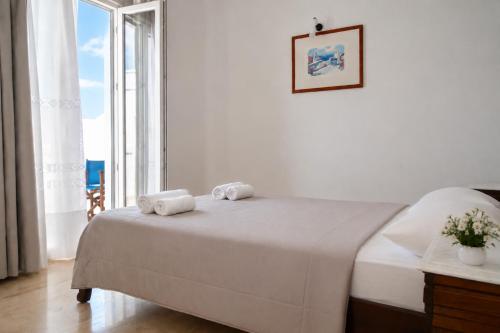 a bedroom with a bed and a large window at New Haroula in Fira