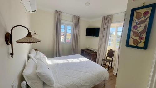 a bedroom with a white bed and two windows at Pink-Shell in Santiago de Riba-Ul