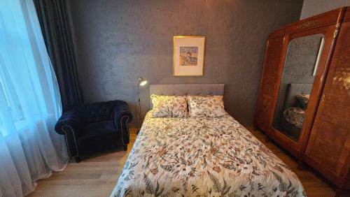 a bedroom with a bed and a chair at Keskallee Charm in Kohtla-Järve