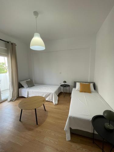 a room with two beds and a table in it at MyLiving in Kardamaina