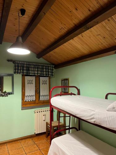 a room with two bunk beds and a wooden ceiling at VACANZE A SESTOLA in Sestola