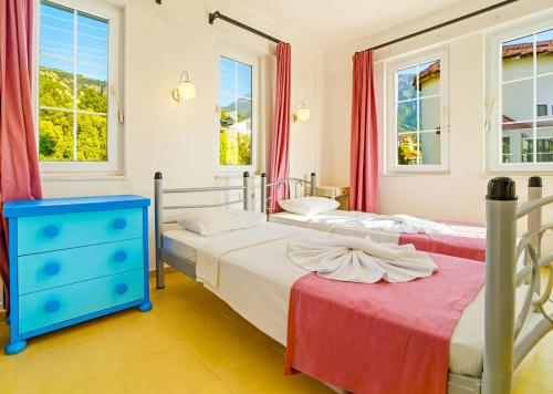 two beds in a bedroom with windows at Summerdays in the Med in Fethiye