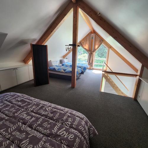a attic room with a bed and a window at Kromven in Merksplas