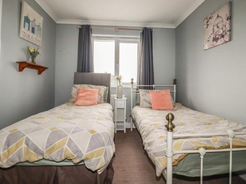 a bedroom with two beds and a window at Treetops in Par