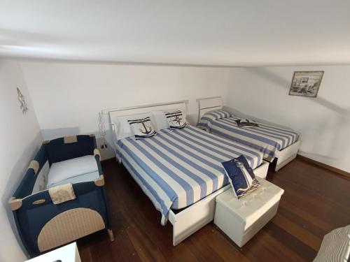 a bedroom with two beds and a chair at Holiday House Piccirillo in Vietri sul Mare