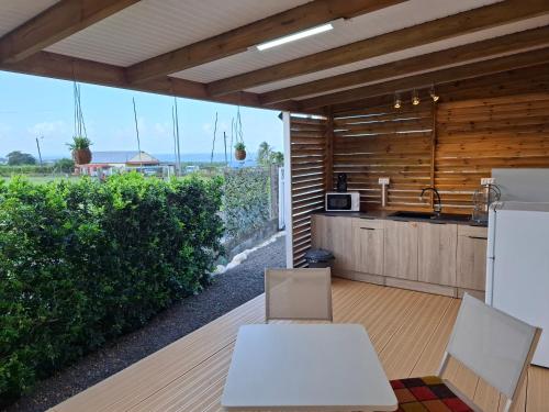 a kitchen with two white tables and a counter at bungalow détente in Capesterre-Belle-Eau