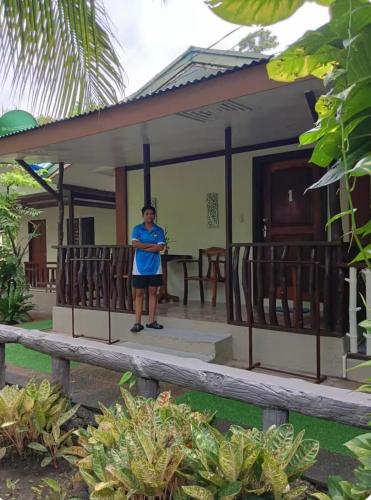 a woman standing on the porch of a house at Ennas Place guest house in Coron