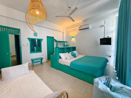 a bedroom with a green bed and a couch at Trinco Beach by DSK in Trincomalee