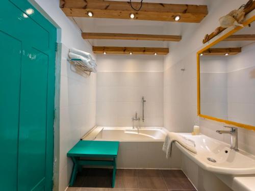 a bathroom with a tub and a sink and a green door at Trinco Beach by DSK in Trincomalee
