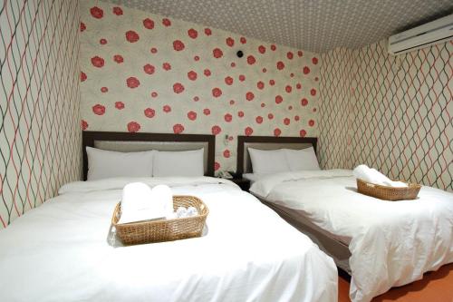 two beds in a room with red hearts on the wall at Happiness Inn in Taipei