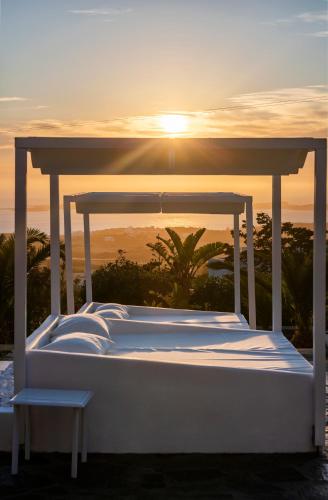 a bed with the sunset in the background at Chrysalis Nature Villa 4 in Kampos Paros