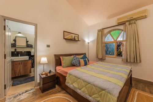 a bedroom with a bed and a window and a mirror at Luxury 2BHK Villa Near Anjuna Beach, North Goa in Anjuna