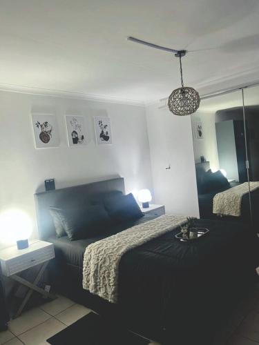 a bedroom with a black bed and a mirror at Angel's Cottage Unit 2 in Paarl