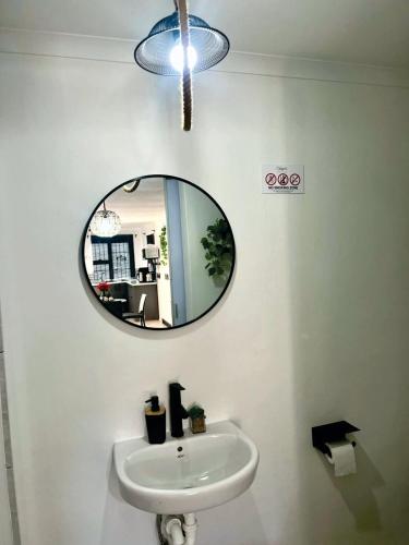 a bathroom with a sink and a mirror on the wall at Angel's Cottage Unit 2 in Paarl