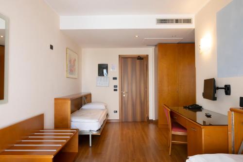 a room with two beds and a desk in it at Parc Hotel Casa Mia in Lazise