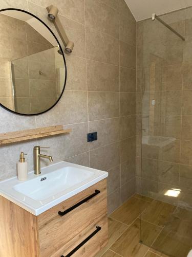a bathroom with a sink and a shower at Rajskie Domki in Sadowie