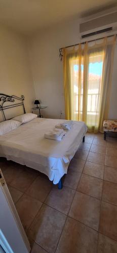 a bedroom with a large bed and a window at Hill View in Nikiti
