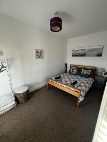 a bedroom with a bed and a table in it at Y Mor Cosy Apartment in Tywyn