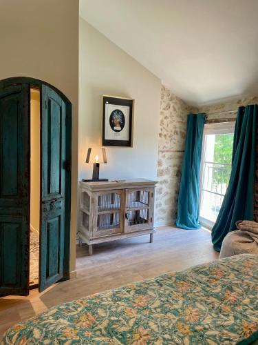 a bedroom with a bed and a dresser and a window at La Bastide Chamarrée in Camaret-sur-Aigues