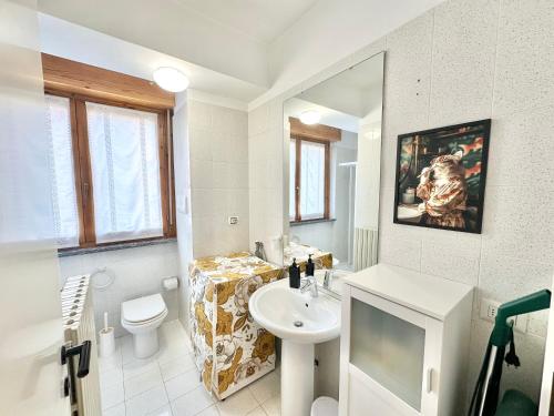 a bathroom with a sink and a toilet and a mirror at La casa di AngeLis in Stezzano