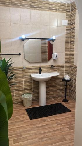 a bathroom with a sink and a mirror at زهرة الهدا in Al Hada