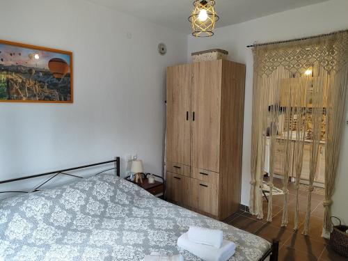 a bedroom with a bed and a wooden cabinet at Citrus Home in Chorefto