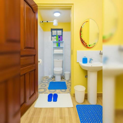 a bathroom with a sink and a toilet and a mirror at Shwari Home Stays in Kisii