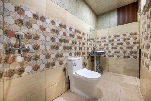 a bathroom with a toilet and a tiled wall at Valley Vista Rooms l Restaurant and Cafe l Forest Treks l Kufri by Exotic Stays in Kūfrī