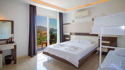 a bedroom with two bunk beds and a desk at Kas Maki Hotel in Kaş