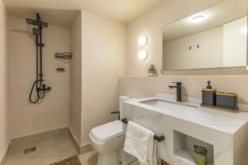 a bathroom with a toilet and a sink with a mirror at Happy Cactus 1BR Apartment In Batroun Souks in Batroûn