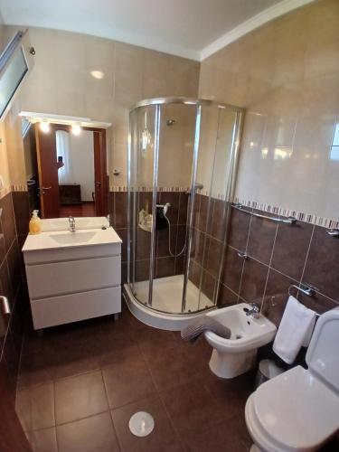 a bathroom with a shower and a sink and a toilet at Lúcia's House in Santa Cruz
