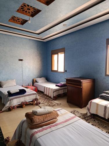 a room with three beds and a desk in it at Jnan Narjiss atlas in Asni