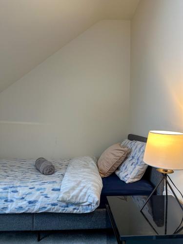 a bed in a room with a lamp and a table at The Calm Space Room in Balderton