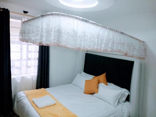 a bedroom with a bed with a canopy at Open Haven One Bedroom Apartments in Ongata Rongai 
