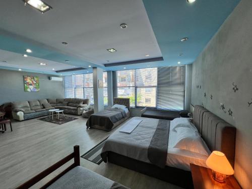 a bedroom with a bed and a living room at Host Apartments in Shkodër