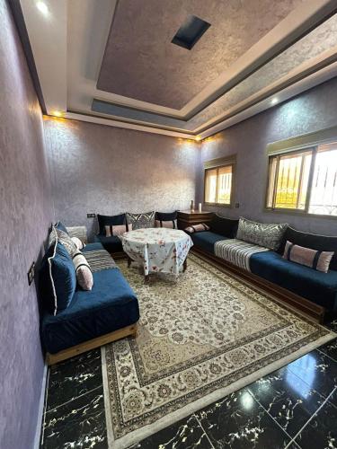a living room with blue couches and a table at Jnan Narjiss atlas in Asni