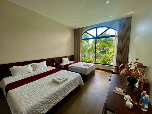 a bedroom with a large bed and a large window at Tam Cốc mountain view Villa in Ninh Binh