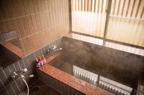 a bathroom with a sink and a shower at Tanakaya in Kurobe