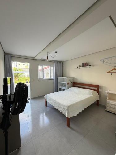 a bedroom with a bed and a desk in it at Espaço inteiro e tranquilo in São José