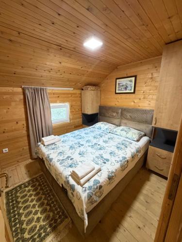 a bedroom with a bed in a wooden cabin at Nana Dea in Utjeha