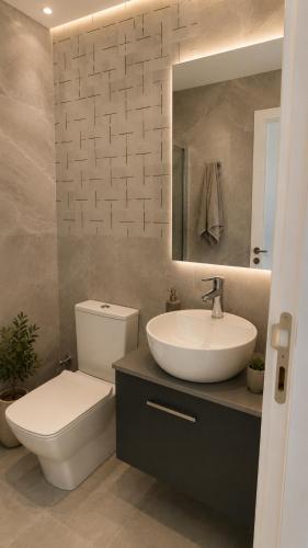 a bathroom with a sink and a toilet and a mirror at Studıo Iskele 150 in Aglantzia